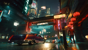 Una captura de pantalla de Nigth City. Una ciudad futurista, con edificios altos llenos de luces que brillan sobre un cielo nocturno. La calle desde la que se toma la imagen tiene una gran puerta china, dos coches futuristas entran en ella. Farolillos y letros en chino decoran las paredes de la calle.
