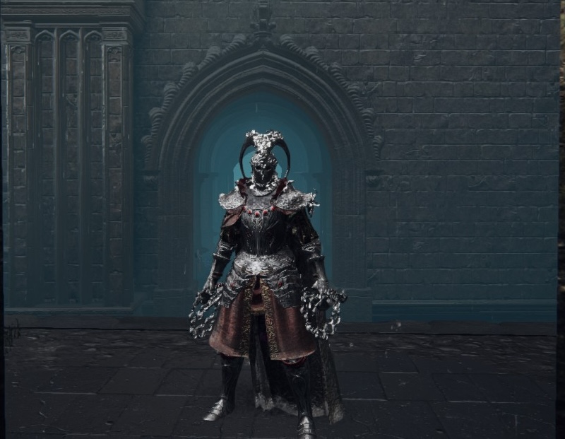 Vanessita Smithers de pie ante un portal de piedra con arco apuntado. Viste una ornada armadura de placas sin grebas o brazales y en cada mano tiene un látigo de espinas